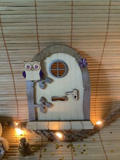 a wooden door with an owl on it next to some candles and other decorations in front of the window