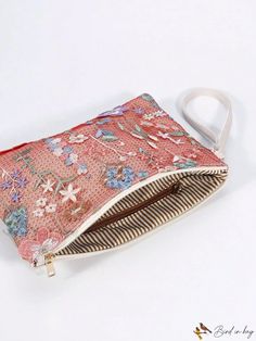 a small purse with flowers and stripes on the inside is sitting on a white surface