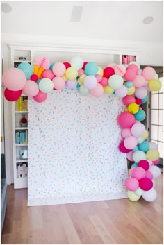 balloons and confetti decorate the backdrop for a birthday party at home or office