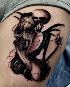 a woman with a skull on her thigh holding an arrow in the shape of a heart