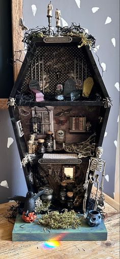 a dollhouse with lots of furniture and decorations on it's sides, including a birdcage