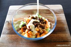 a glass bowl filled with salad and dressing