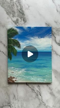 an image of the beach with palm trees on it and a video playing button in the middle