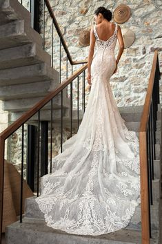 a woman in a wedding dress standing on some stairs