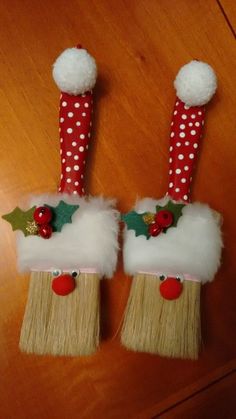 two christmas decorations made out of brooms on top of a wooden table with polka dots