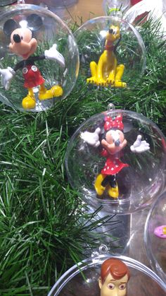 mickey mouse ornaments are sitting on top of the christmas tree ornament set up