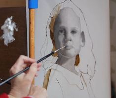 a woman is painting a portrait on a canvas