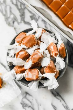 a bowl filled with caramel marshmallows on top of a marble counter