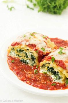 two ravioli stuffed with spinach and cheese on a white plate next to parsley