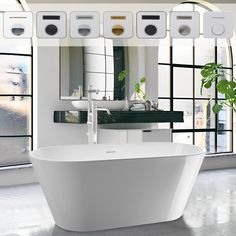 a white bath tub sitting in front of a window next to a potted plant