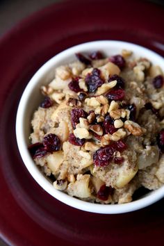 a bowl filled with oatmeal and cranberries on top of a red plate