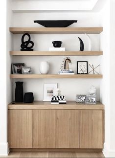 the shelves in this living room are filled with black and white items, such as vases