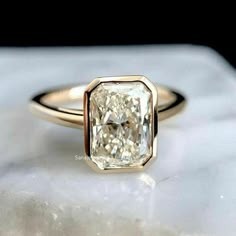 a yellow diamond ring sitting on top of a white rock