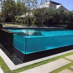 an empty swimming pool in the middle of a yard with grass and trees around it