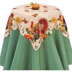 a table with a turkey and sunflowers design on it, sitting next to a pumpkin