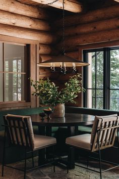 a dining room table with chairs and a potted plant