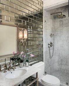 a bathroom with a sink, mirror and shower head in the wall next to it