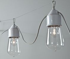 two light bulbs are hanging from a string