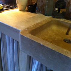 a kitchen sink sitting under a faucet next to a counter