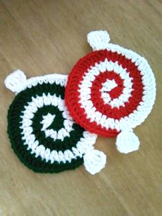 two crocheted coasters sitting on top of a wooden table