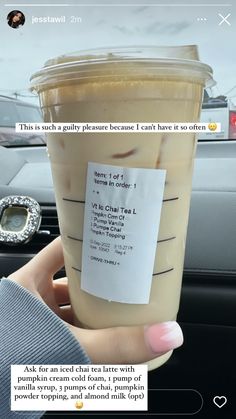 someone is holding up a cup of iced coffee in their hand with a note attached to it