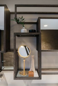 a shelf with a mirror, vase and other items on it in a room that appears to be modern