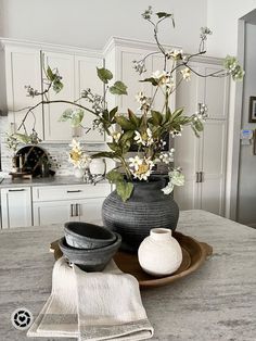 a vase with flowers in it sitting on top of a table next to two dishes