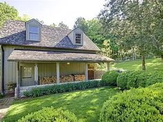 the house is surrounded by hedges and trees