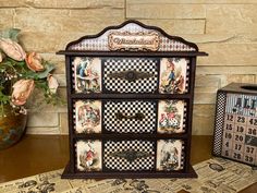 an old fashioned dresser with many pictures on the front and sides, sitting next to a flower pot