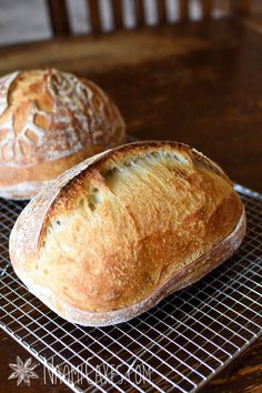 two loaves of bread sit on a cooling rack