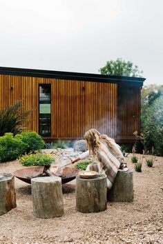 a woman sitting in front of a fire pit