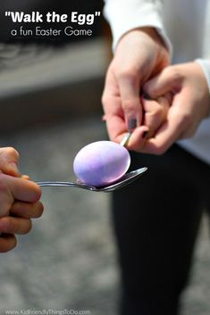 a person holding a spoon with an egg on it