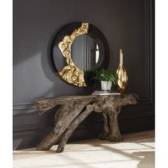 a wooden table topped with a mirror next to a potted plant on top of it