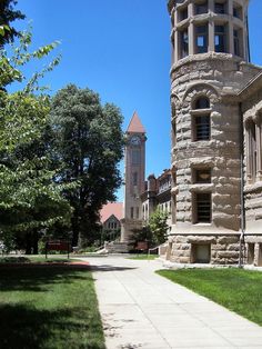 an old building with a clock tower in the middle of it's front yard