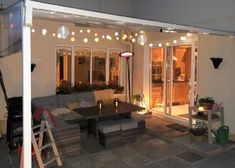 an outdoor living area with patio furniture and lights