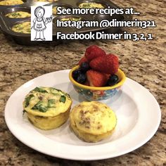 two muffins on a plate with strawberries and blueberries in a bowl