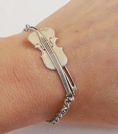 a silver bracelet with a violin on it