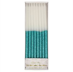 teal glitter candles in a box with white and blue tips on the top,