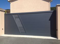 a garage with a gate that is open and closed on the side of a house