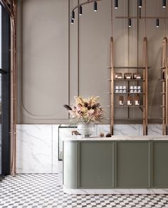 an elegant kitchen with marble counter tops and gold accents on the walls, along with white checkered flooring