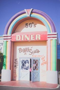 the front entrance to a diner that is painted in rainbow colors