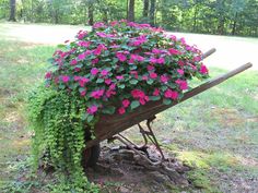 a wheelbarrow filled with pink flowers and greenery