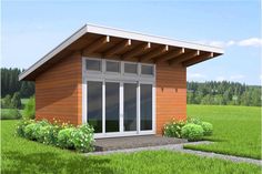 a small wooden building sitting on top of a lush green field