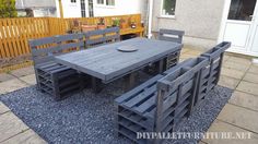 an outdoor table and chairs made out of pallet wood with gravel on the ground