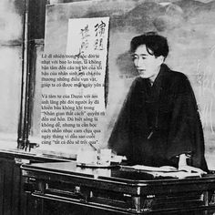 an old photo of a man sitting at a desk in front of a chalkboard