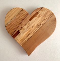 a wooden heart shaped cutting board on a white wall