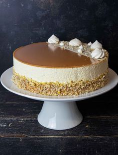 a cake sitting on top of a white plate covered in frosting and toppings