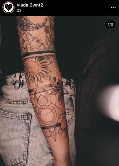 a woman's arm with tattoos on it and sunflowers in the background