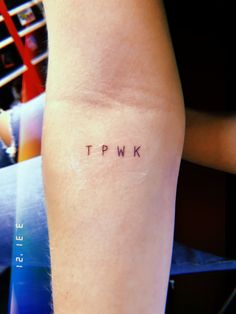 the word tpwk written on someone's leg