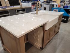 a kitchen island in a store with an oven and sink on display next to it